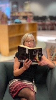 Cheryl Miller reading the book named Cinder. 